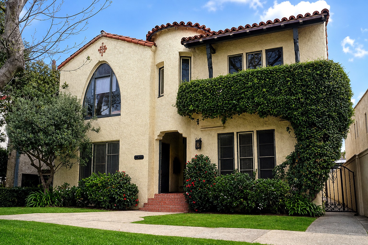 Spanish-style front exterior with terracotta rooflines and mature landscaping